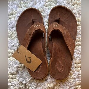 OluKai leather flip flops. Never worn. 
Smoke free home.